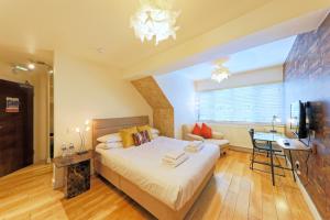 1 dormitorio con cama, mesa y TV en Stay 2a Boutique Rooms en Folkestone