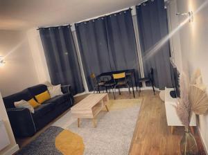 a living room with a couch and a table at Le Nuage de Jaude II in Clermont-Ferrand