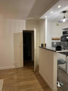 an empty kitchen with a counter and a door to a room at Le Nuage de Jaude II in Clermont-Ferrand