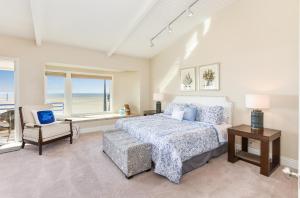 1 dormitorio con 1 cama, 1 silla y 1 ventana en Multi Level Oceanfront Home With Oceanviews and Private Patio on the Sand, en Newport Beach