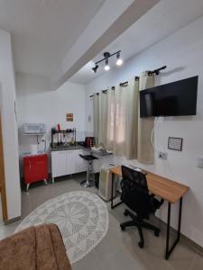 a living room with a desk and a tv on a wall at Studio fantástico in São Paulo