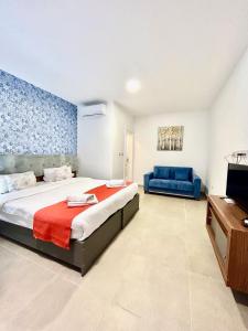 a bedroom with a large bed and a blue couch at Marina Suites & apartments - Self catering - by Tritoni hotels in Il-Gżira