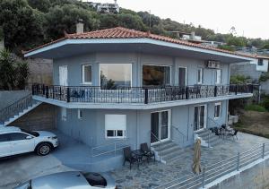 a house with a car parked in front of it at Aegean Beachfront House in Petriaí