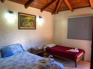 een slaapkamer met een bed en een projectiescherm bij VÉLEZ Beach Hotel in San Juan del Sur