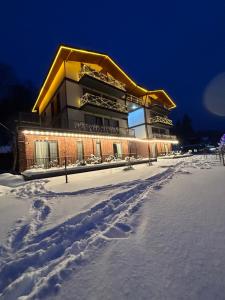 a building in the snow with footprints in the snow at Bakuriani Hotel Apartments 301 in Bakuriani