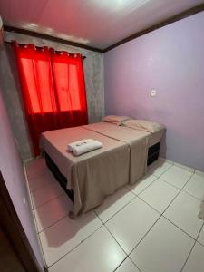1 dormitorio con 1 cama y ventana roja en Hoje Apartamentos, en Feira de Santana