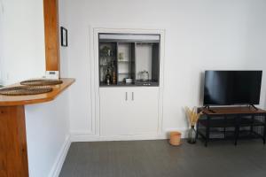 ein Wohnzimmer mit einem TV und einer weißen Tür in der Unterkunft Maison de ville - Chelles Close to Disney & Paris in Chelles