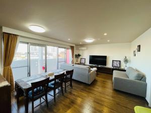 una sala de estar con una mesa y un sofá en Mr,KINJO in RYCOM Kitanakagusuku - Vacation STAY 59274v, en Shimabuku