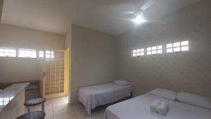 1 dormitorio con 2 camas, mesa y sillas en Chalé Cipó Maia en Serra do Cipo