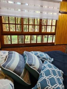 - une chambre avec des oreillers sur un canapé et des fenêtres dans l'établissement Chácara.lazer.cxs, à Caxias do Sul