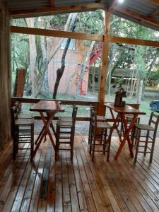 un portico in legno con tavoli e sedie su un pavimento in legno di Chácara.lazer.cxs a Caxias do Sul