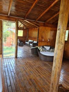 porche cubierto con cama y sillas en el suelo de madera en Chácara.lazer.cxs en Caxias do Sul