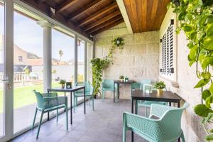 eine Terrasse mit Tischen, Stühlen und Fenstern in der Unterkunft Casa Lali Habitación 1 in La Laguna