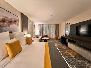 a hotel room with a large bed and a television at Enala Hotel- Umluj in Umm Lujj