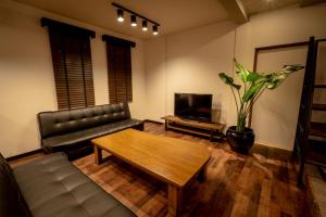 小樽的住宿－Lifehouse IPPO - Vacation STAY 63442v，客厅配有真皮沙发和茶几