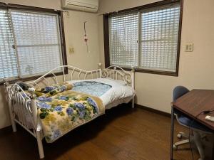 a bedroom with a bed and a desk and windows at Shin-SHIN-Kakamigahara - Vacation STAY 16114 in Kakamigahara