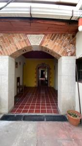uma entrada para um edifício com piso de tijolo e parede amarela em Casa colonial em Quetzaltenango