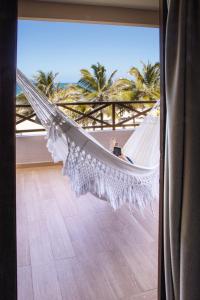 a person sitting in a hammock on a balcony at Hotel Varandas Beach in Águas Belas