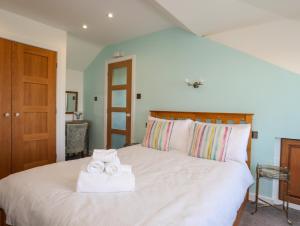 a bedroom with a large white bed with towels on it at Drws y Gorlan in Llanerchymedd