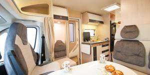 un interior de una caravana con una mesa con pan. en Alquiler Autocaravanas en Barcelona, en Montcada i Reixac