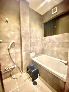 a bathroom with a bath tub and a shower at Geku-mae Bettei Hoshiori - Vacation STAY 65143v in Ise