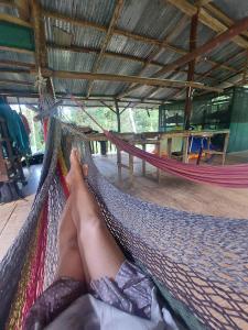 a person laying in a hammock with their feet up at Rio Agujitas Eco-Jungle in Drake