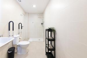 a white bathroom with a toilet and a sink at Beautiful OCEANOGRAFIC Flats Valencia in Valencia