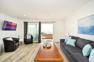 a living room with a couch and a table at Updated Home on the Boardwalk with Private Rear Unit in Newport Beach