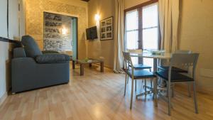 a living room with a couch and a table with chairs at Casa de los Mozárabes by Toledo AP in Toledo