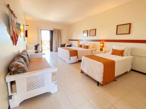 a hotel room with two beds and a couch at Hotel Varandas Beach in Águas Belas