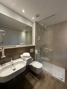 y baño con lavabo, aseo y ducha. en Hotel Nar, en Trebinje