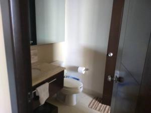 ein kleines Badezimmer mit Toilette und Waschbecken in der Unterkunft Casa Mccraren Torre 3-302 at Mayan Lakes in Playa Encanto + 15 Fotos