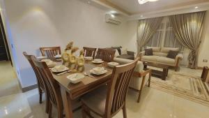 a dining room with a table and chairs and a couch at Madinaty apartment شقة فندقية مفروشة سوبر لوكس في مدينتي in Madinaty