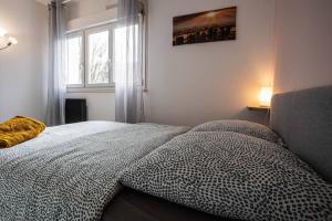 a bedroom with a bed with a comforter and a window at *Cosy Home 20' Paris 25' Disney - Free WIFI* in Villiers-sur-Marne