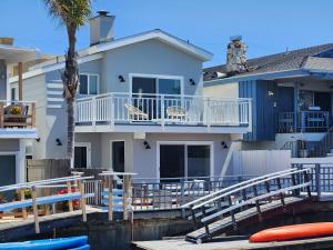 una casa en el agua con un muelle en Sunset Island Waterfront Home with Kayaks across the Street from the Beach, en Sunset Beach