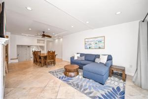 a living room with a blue couch and a table at Sunset Island Waterfront Home with Kayaks across the Street from the Beach in Sunset Beach