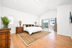 a white bedroom with a bed and a large window at Sunset Island Waterfront Home with Kayaks across the Street from the Beach in Sunset Beach