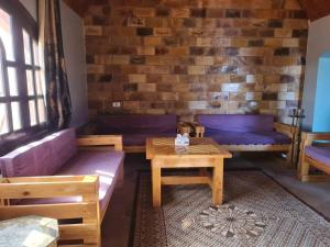 a living room with couches and a table at Nubian Magic villa in Nag` el-Ramla