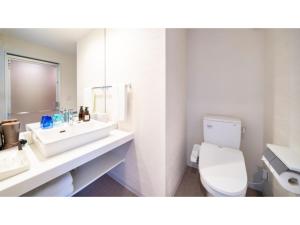 Baño blanco con aseo y lavamanos en Hotel Torifito Miyakojima Resort - Vacation STAY 79487v, en Isla Miyako