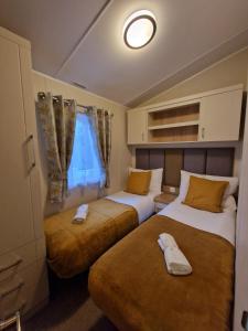 Beautiful Caravan near Edinburgh nr 9 في Port Seton: غرفة نوم بسريرين ونافذة