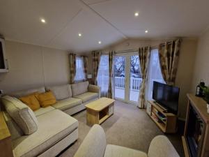 Beautiful Caravan near Edinburgh nr 9 في Port Seton: غرفة معيشة مع أريكة وتلفزيون