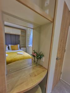 a bedroom with a bed and a table with a mirror at Beautiful Caravan near Edinburgh nr 9 in Port Seton