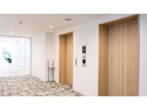 um corredor de escritório com portas de madeira e um corredor em Hotel Torifito Miyakojima Resort - Vacation STAY 79488v em Ilhas Miyako