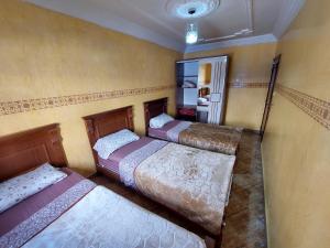 een kamer met drie bedden in een kamer bij Private appartement in the centre of Taghazout in Taghazout