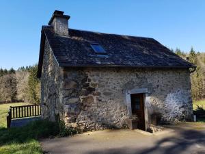an old stone building with a window on it at Gîte de France Le fournil des prades 2 épis - Gîte de France 2 personnes MAE-6414 in Soursac +3 photos