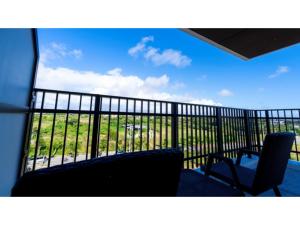 balcón con 2 sillas y vistas al océano en Hotel Torifito Miyakojima Resort - Vacation STAY 79481v, en Isla Miyako