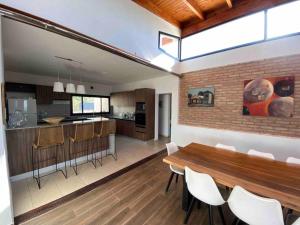 a kitchen and dining room with a wooden table and chairs at Casa en Ascochinga B.° cerrado. Sierras de Córdoba in Cordoba