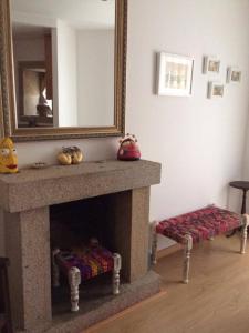 a living room with a fireplace and a mirror at Terraço da Vila in Ponte de Lima