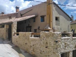 un edificio de piedra con una pared de piedra delante de él en Mirador del Maestrazgo, en Ejulve