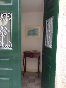 a green door in a room with a table at Terraço da Vila in Ponte de Lima